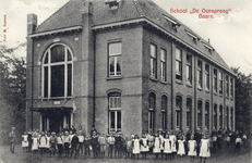 7587 Gezicht op de linker- en voorzijde van de lagere school De Oorsprong te Baarn.